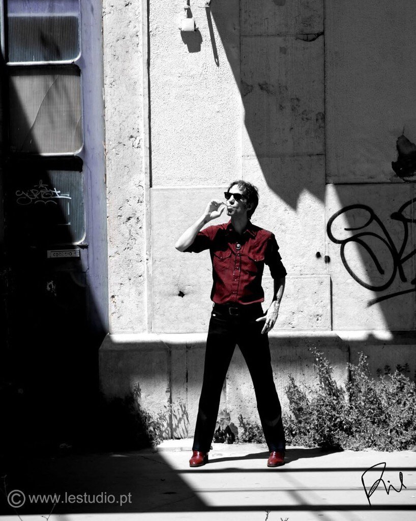 Portrait, homme en rouge fumant dans une ruelle de Lisbonne